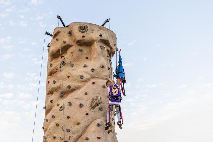 two children climb down a rock wall
