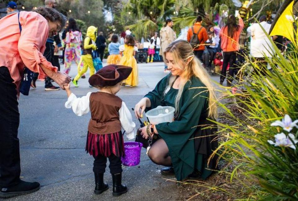 woman kneeling and giving young child candy